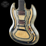 A custom electric guitar with a distinctive wavy, striped wood grain finish in light natural wood and dark black/charcoal layers. The guitar features a double-cutaway body shape, dual humbucker pickups, and chrome hardware, shown against a solid black background with a Tone Shop watermark in the top left corner.