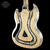 The back of an electric guitar made of natural wood with a distinctive wavy black and gray flame-burned pattern, shown against a solid black background with a Tone Shop watermark in the top left.