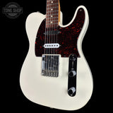 Fender Telecaster-style electric guitar with an off-white body, dark red glitter pickguard, black control plate, and chrome hardware, shown against a black background with a Tone Shop watermark in the upper left.