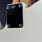Close-up of the back of an electric guitar body, showing a glossy black plate secured with four silver screws, featuring a small blue CE mark sticker and a light wood neck joint at the top.