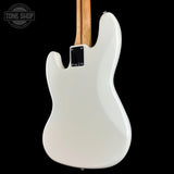 The back of a white electric guitar with a natural wood neck, shown against a solid black background with a Tone Shop watermark in the top left corner.