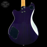 The back of an electric guitar with a glossy dark purple body, a light wood neck, chrome hardware, and a black pickguard, shown against a solid black background with a Tone Shop watermark in the top-left corner.