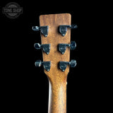 Close-up of the headstock of an acoustic guitar, showing six black tuning pegs with 'Tone Shop' branding on a solid black background.