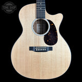 A Taylor acoustic guitar with a natural flamed maple top, black pickguard, and dark fretboard, shown against a solid black background. A 'TONE SHOP' watermark is visible in the top-left corner.