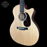 A cutaway acoustic guitar with a natural wood finish and a dark tortoiseshell pickguard, shown against a solid black background with a Tone Shop watermark in the top-left corner.