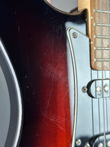 Close-up of a guitar's neck and headstock with visible wear.
