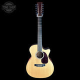 A 12-string acoustic-electric guitar with a natural wood finish and cutaway body, shown against a solid black background with a Tone Shop watermark in the top-left corner.