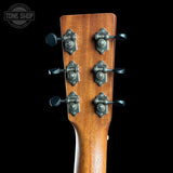 Close-up of a guitar headstock with tuning pegs on a black background, featuring the Tone Shop logo.