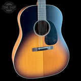 Acoustic guitar with a sunburst finish on a black background, featuring the Tone Shop logo.