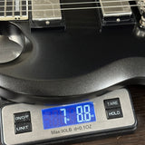 Guitar on a digital scale displaying weight