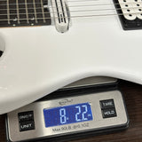 White electric guitar on a digital scale displaying weight