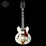A white electric guitar with a red glitter pickguard, gold hardware, and a black headstock, shown against a solid black background. A 'TONE SHOP' watermark is visible in the top left corner.