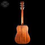 The back of a wooden acoustic guitar, showing the rich grain of the mahogany body and neck, with six silver tuning pegs on the headstock, set against a solid black background.