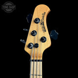 Close-up of a bass guitar headstock with a natural wood finish, four black tuning pegs, and black tuning keys, shown against a solid black background. The headstock features the text 'Bassman Dark Ray' and a circular 'TONE SHOP' watermark is visible in the top-left corner.