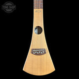 A natural wood soprano ukulele shown vertically against a solid black background, with a Tone Shop watermark in the upper left corner.