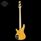 Electric bass guitar with a natural wood finish on a black background, featuring the Tone Shop logo.