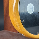 Close-up of a wooden object with a metallic surface, possibly a part of a musical instrument.