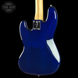 The rear view of an electric guitar body in a glossy deep blue finish, featuring a maple neck and chrome hardware, set against a solid black background.