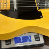 Yellow electric guitar on a digital scale displaying weight