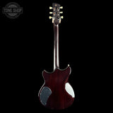 A dark reddish-brown electric guitar shown from the back, featuring a glossy finish, a circular soundhole, and cream-colored tuning pegs, set against a solid black background with a Tone Shop watermark in the top-left corner.