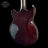 Close-up of the back of an electric guitar body in a glossy dark reddish-brown finish, shown against a black background with a Tone Shop watermark in the upper left.
