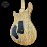 Wooden electric guitar body with a black pickguard on a black background, featuring 'Tone Shop' logo.