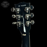 Close-up of a Gibson electric guitar headstock, showing six silver tuning pegs, model number CS 701076, and the Gibson logo on a black background.