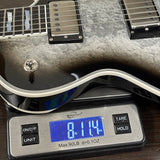 Silver electric guitar on a digital scale displaying weight