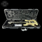 Electric guitar in a hard case with 'Tone Shop' logo.