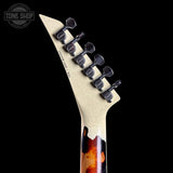 Close-up of a guitar's headstock with tuning pegs on a black background, featuring the 'Tone Shop' logo.