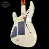 Guitar body with a distressed white finish on a black background, featuring the Tone Shop logo.