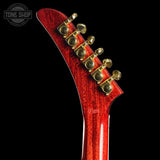 Close-up of a red guitar headstock with tuning pegs on a black background, featuring the Tone Shop logo.