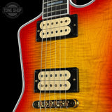 Close-up of a red and orange electric guitar with visible brand logo.