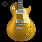 Gold electric guitar with a 'Tone Shop' logo in the corner