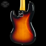 Close-up of the back of a Fender Stratocaster electric guitar showing a classic sunburst finish that transitions from bright amber-orange in the center to dark brown and black around the edges, set against a solid black background.