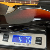 Close-up of a glossy sunburst electric guitar body resting on a digital scale displaying 9.75 lbs.