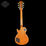 Back view of a wooden electric guitar with 'Tone Shop' logo in the corner.