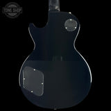 The back of a glossy black electric guitar, showing the body contour, clear pickguard, and silver hardware against a solid black background.