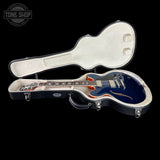 Electric guitar in a hard case with 'Tone Shop' branding.