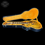Yellow electric guitar in an open case with 'Tone Shop' logo.