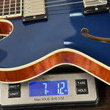 Blue electric guitar on a digital scale displaying weight.