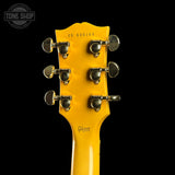 Yellow guitar headstock with tuning pegs on a black background, featuring the Gibson logo.