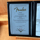 Fender certificate of authenticity in a black frame on a wooden surface