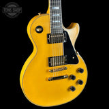 Yellow electric guitar on a black background with 'Tone Shop' logo.