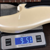 A close-up of a glossy cream-colored guitar body resting on a digital scale displaying 9.51 lbs.