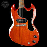 A classic electric guitar with a glossy reddish-orange sunburst finish, black pickguard, and chrome hardware, shown against a solid black background with a Tone Shop watermark in the top left corner.