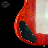 Close-up of the lower bout corner of a red electric guitar body with a black pickguard, shown against a black background with a Tone Shop watermark in the top left.