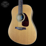 Acoustic guitar with a visible brand logo on a black background