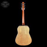 Back view of a wooden acoustic guitar on a black background with 'Tone Shop' branding.