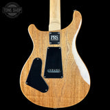 Wooden electric guitar with PRS logo on a black background